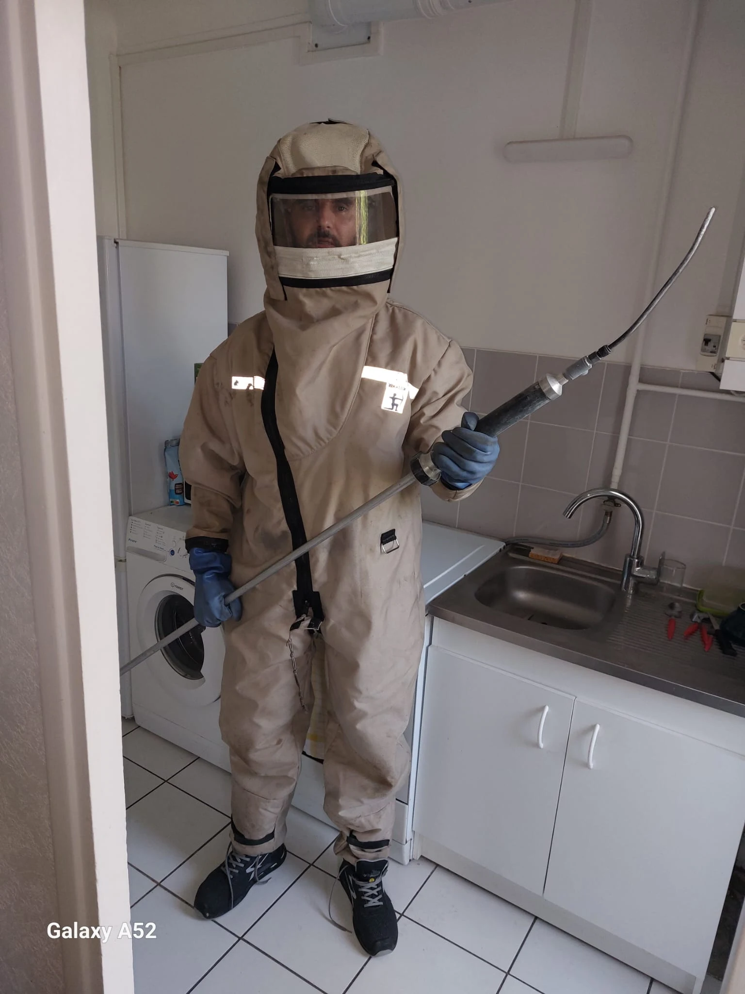 Technicien utilisant lance télescopique professionnelle pour destruction nid frelons